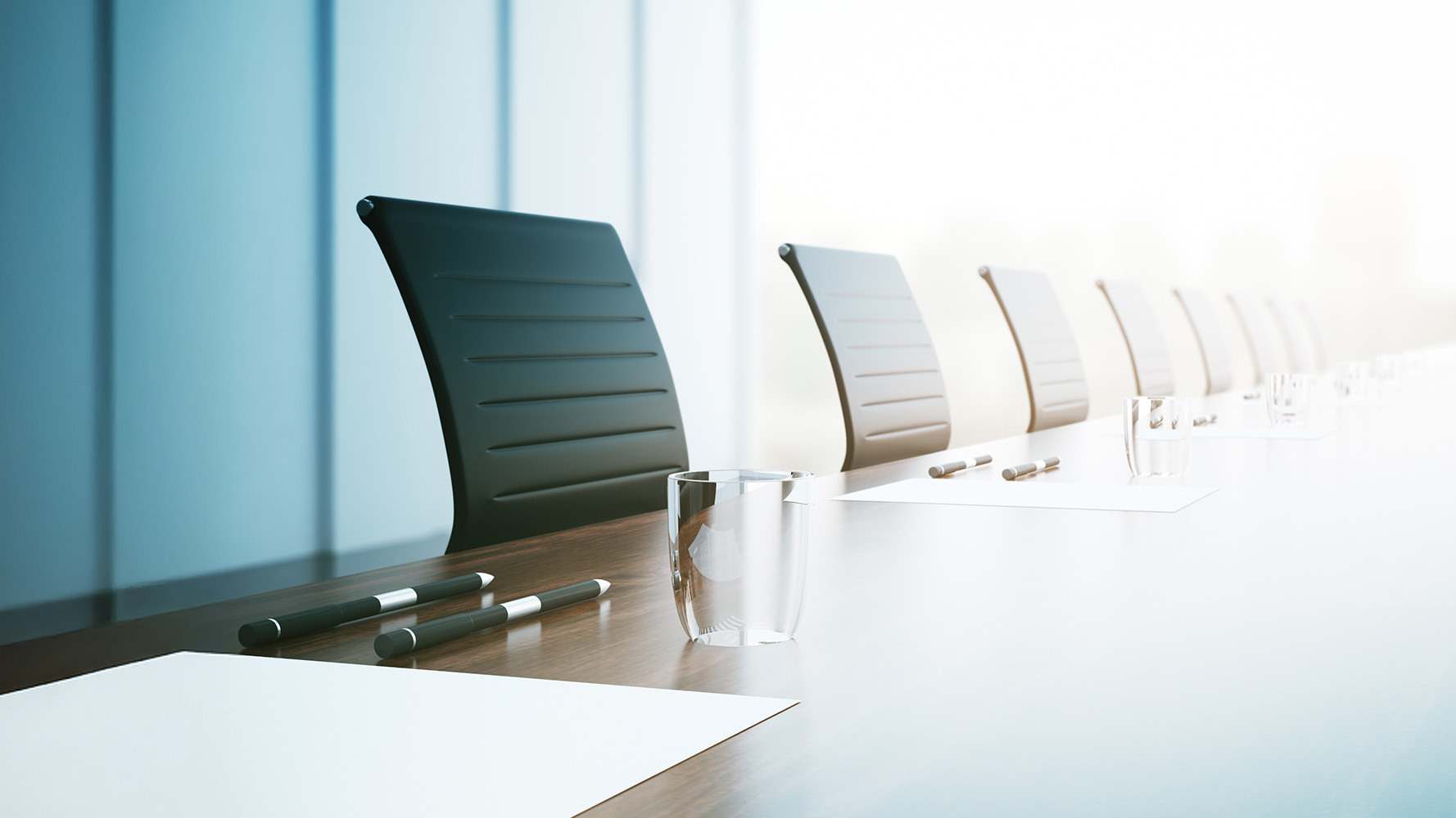 Image of an office Board room, showing a desk, chairs and a notepad